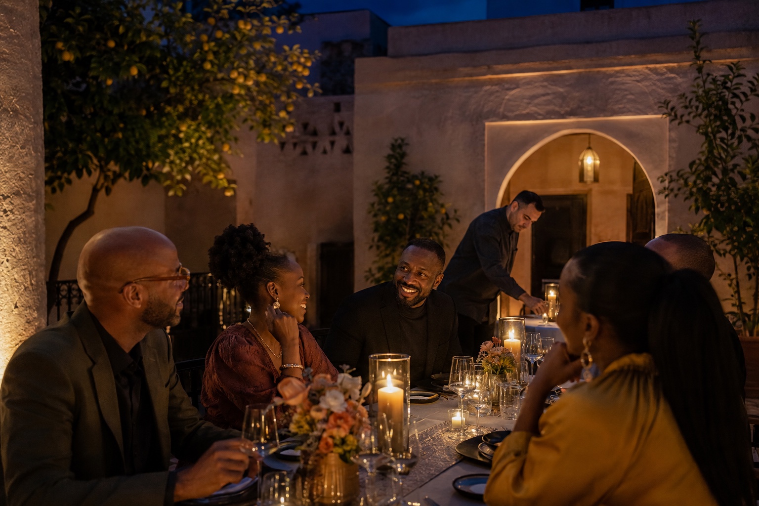 Friends sharing a privately hosted courtyard dinner